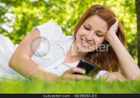 To use this stock image in your creative project, please select the size you need over to the right and click the "Add to Cart" button.
Your downloaded image will come with the Cutcaster watermark removed so don’t worry about the watermark you see on this page. Pretty redhead lying on the grass sending a text stock photo, Pretty redhead lying on the grass sending a text on a sunny day by Wavebreak Media