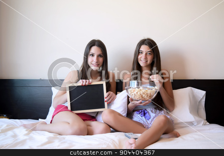 To use this stock image in your creative project, please select the size you need over to the right and click the "Add to Cart" button.
Your downloaded image will come with the Cutcaster watermark removed so don’t worry about the watermark you see on this page. Best friends watching tv or a movie in bed stock photo, Two beautiful young women in bed watching a movie or tv, and eating popcorn. Chalkboard with copyspace. by nicolas menijes