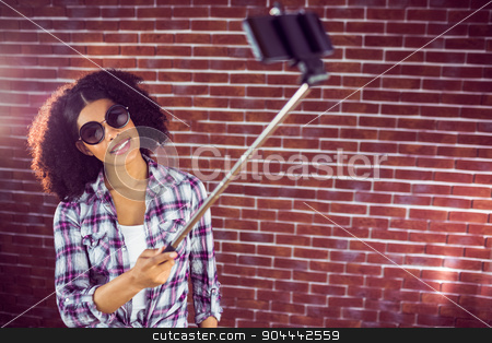 To use this stock image in your creative project, please select the size you need over to the right and click the "Add to Cart" button.
Your downloaded image will come with the Cutcaster watermark removed so don’t worry about the watermark you see on this page. Attractive hipster taking selfies with selfiestick stock photo, Attractive hipster taking selfies with selfiestick against red brick background by Wavebreak Media