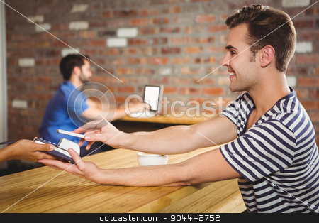 To use this stock image in your creative project, please select the size you need over to the right and click the "Add to Cart" button.
Your downloaded image will come with the Cutcaster watermark removed so don’t worry about the watermark you see on this page. Paying for a croissant and a coffee with his smartphone stock photo, Paying for a croissant and a coffee with his smartphone at a cafe by Wavebreak Media