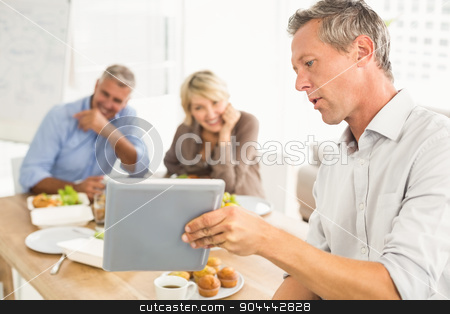 To use this stock image in your creative project, please select the size you need over to the right and click the "Add to Cart" button.
Your downloaded image will come with the Cutcaster watermark removed so don’t worry about the watermark you see on this page. Casual business people looking at tablet while lunch stock photo, Casual business people looking at tablet while lunch in the office by Wavebreak Media