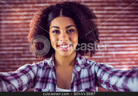 To use this stock image in your creative project, please select the size you need over to the right and click the "Add to Cart" button.
Your downloaded image will come with the Cutcaster watermark removed so don’t worry about the watermark you see on this page. Attractive young woman taking selfies stock photo, Portrait of attractive young woman taking selfies against red brick background by Wavebreak Media