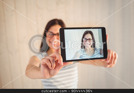 To use this stock image in your creative project, please select the size you need over to the right and click the "Add to Cart" button.
Your downloaded image will come with the Cutcaster watermark removed so don’t worry about the watermark you see on this page. Pretty hipster taking selfie with tablet stock photo, Pretty hipster taking selfie with tablet on wooden planks background by Wavebreak Media