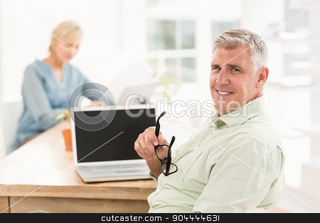 To use this stock image in your creative project, please select the size you need over to the right and click the "Add to Cart" button.
Your downloaded image will come with the Cutcaster watermark removed so don’t worry about the watermark you see on this page. Smiling businessman looking at the camera stock photo, Portrait of a smiling businessman working on laptop at office by Wavebreak Media