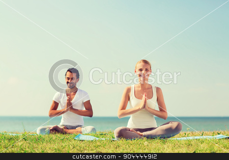 To use this stock image in your creative project, please select the size you need over to the right and click the "Add to Cart" button.
Your downloaded image will come with the Cutcaster watermark removed so don’t worry about the watermark you see on this page. smiling couple making yoga exercises outdoors stock photo, fitness, sport, friendship and lifestyle concept - smiling couple making yoga exercises sitting on mats outdoors by Syda Productions