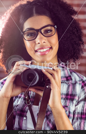 To use this stock image in your creative project, please select the size you need over to the right and click the "Add to Cart" button.
Your downloaded image will come with the Cutcaster watermark removed so don’t worry about the watermark you see on this page. Attractive smiling hipster holding camera stock photo, Portrait of attractive smiling hipster holding camera against red brick background by Wavebreak Media