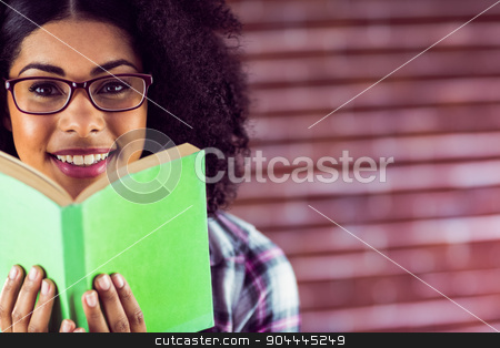 To use this stock image in your creative project, please select the size you need over to the right and click the "Add to Cart" button.
Your downloaded image will come with the Cutcaster watermark removed so don’t worry about the watermark you see on this page. Attractive smiling hipster holding book stock photo, Portrait of attractive smiling hipster holding book against red brick background by Wavebreak Media