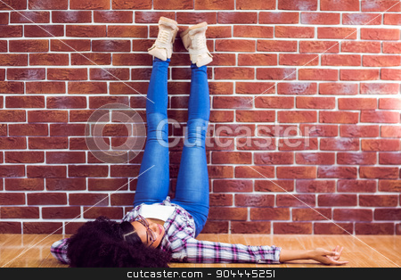 To use this stock image in your creative project, please select the size you need over to the right and click the "Add to Cart" button.
Your downloaded image will come with the Cutcaster watermark removed so don’t worry about the watermark you see on this page. Attractive hipster lying on ground and holding legs up stock photo, Attractive hipster lying on ground and holding legs up against red brick background by Wavebreak Media
