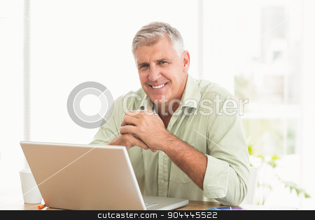 To use this stock image in your creative project, please select the size you need over to the right and click the "Add to Cart" button.
Your downloaded image will come with the Cutcaster watermark removed so don’t worry about the watermark you see on this page. Smiling businessman working on a laptop stock photo, Portrait of a smiling businessman working on a laptop at office by Wavebreak Media