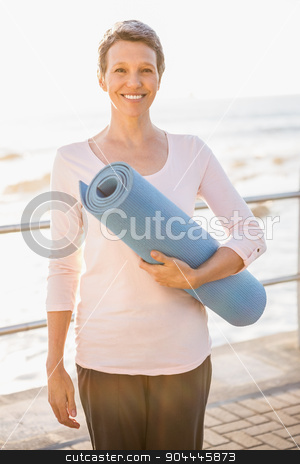 To use this stock image in your creative project, please select the size you need over to the right and click the "Add to Cart" button.
Your downloaded image will come with the Cutcaster watermark removed so don’t worry about the watermark you see on this page. Smiling sporty woman with exercise mat stock photo, Portrait of smiling sporty woman with exercise mat at promenade by Wavebreak Media