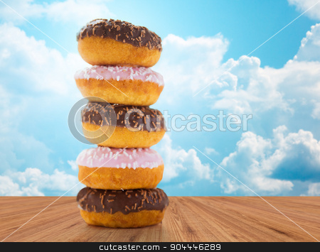 To use this stock image in your creative project, please select the size you need over to the right and click the "Add to Cart" button.
Your downloaded image will come with the Cutcaster watermark removed so don’t worry about the watermark you see on this page. close up of glazed donuts pile over blue sky stock photo, food, junk-food and eating concept - close up of glazed donuts pile on wooden table over blue sky and clouds background by Syda Productions