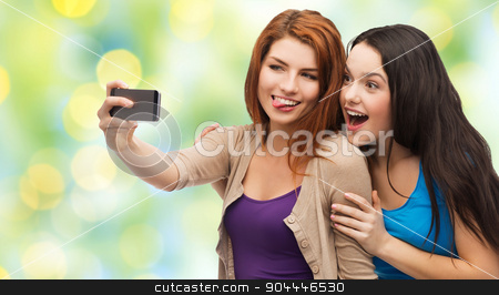 To use this stock image in your creative project, please select the size you need over to the right and click the "Add to Cart" button.
Your downloaded image will come with the Cutcaster watermark removed so don’t worry about the watermark you see on this page. happy teenage girls taking selfie with smartphone stock photo, technology, friendship and people concept - two smiling teenage girls or young women taking selfie with smartphone over green lights background by Syda Productions