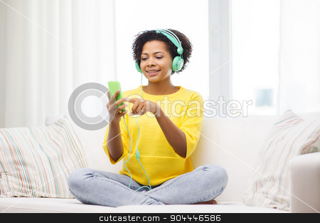 To use this stock image in your creative project, please select the size you need over to the right and click the "Add to Cart" button.
Your downloaded image will come with the Cutcaster watermark removed so don’t worry about the watermark you see on this page. happy african woman with smartphone and headphones stock photo, people, technology and leisure concept - happy african american young woman sitting on sofa with smartphone and headphones listening to music at home by Syda Productions