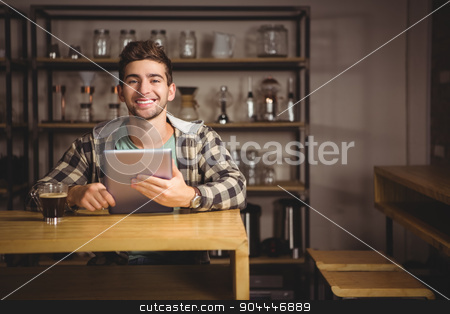 To use this stock image in your creative project, please select the size you need over to the right and click the "Add to Cart" button.
Your downloaded image will come with the Cutcaster watermark removed so don’t worry about the watermark you see on this page. Smiling hipster having coffee and holding tablet computer stock photo, Portrait of smiling hipster having coffee and holding tablet computer at coffee shop by Wavebreak Media
