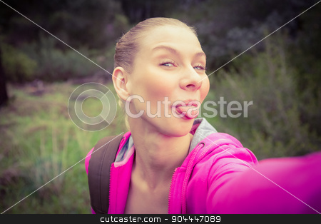 To use this stock image in your creative project, please select the size you need over to the right and click the "Add to Cart" button.
Your downloaded image will come with the Cutcaster watermark removed so don’t worry about the watermark you see on this page. Smiling female hiker taking a funny selfie stock photo, Portrait of a smiling female hiker taking a funny selfie in the nature by Wavebreak Media