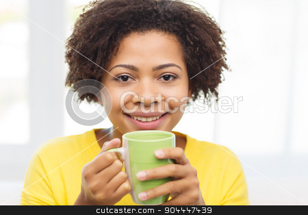 To use this stock image in your creative project, please select the size you need over to the right and click the "Add to Cart" button.
Your downloaded image will come with the Cutcaster watermark removed so don’t worry about the watermark you see on this page. happy african american woman drinking from tea cup stock photo, people, drinks and leisure concept - happy african american woman drinking tea from cup or mug at home by Syda Productions
