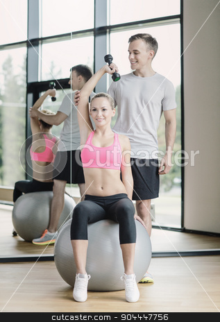 To use this stock image in your creative project, please select the size you need over to the right and click the "Add to Cart" button.
Your downloaded image will come with the Cutcaster watermark removed so don’t worry about the watermark you see on this page. smiling young woman with personal trainer in gym stock photo, fitness, sport, exercising and diet concept - smiling young woman and personal trainer with dumbbell in gym by Syda Productions