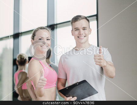 To use this stock image in your creative project, please select the size you need over to the right and click the "Add to Cart" button.
Your downloaded image will come with the Cutcaster watermark removed so don’t worry about the watermark you see on this page. smiling young woman with personal trainer in gym stock photo, fitness, sport, exercising and diet concept - smiling young woman with personal trainer in gym showing thumbs up by Syda Productions