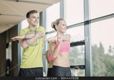 To use this stock image in your creative project, please select the size you need over to the right and click the "Add to Cart" button.
Your downloaded image will come with the Cutcaster watermark removed so don’t worry about the watermark you see on this page. smiling man and woman exercising in gym stock photo, sport, fitness, lifestyle and people concept - smiling man and woman stretching in gym by Syda Productions