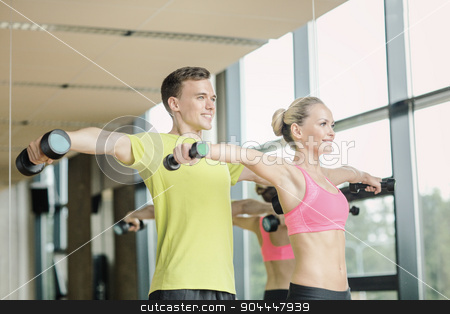 To use this stock image in your creative project, please select the size you need over to the right and click the "Add to Cart" button.
Your downloaded image will come with the Cutcaster watermark removed so don’t worry about the watermark you see on this page. smiling man and woman with dumbbells in gym stock photo, sport, fitness, lifestyle and people concept - smiling man and woman with dumbbells exercising in gym by Syda Productions