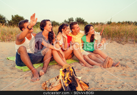 To use this stock image in your creative project, please select the size you need over to the right and click the "Add to Cart" button.
Your downloaded image will come with the Cutcaster watermark removed so don’t worry about the watermark you see on this page. smiling friends in sunglasses on summer beach stock photo, friendship, summer vacation, holidays, gesture and people concept - group of smiling friends sitting near fire and waving hands on beach by Syda Productions