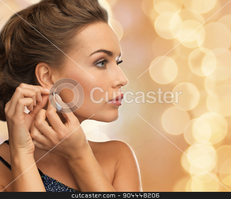 To use this stock image in your creative project, please select the size you need over to the right and click the "Add to Cart" button.
Your downloaded image will come with the Cutcaster watermark removed so don’t worry about the watermark you see on this page. close up of woman wearing earrings stock photo, people, holidays, christmas and glamour concept - close up of beautiful woman wearing earrings over beige lights background by Syda Productions