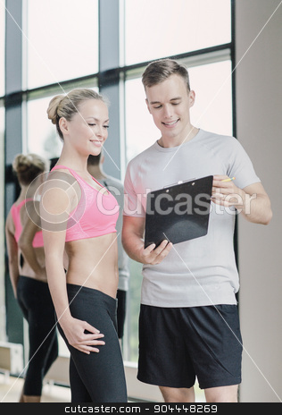 To use this stock image in your creative project, please select the size you need over to the right and click the "Add to Cart" button.
Your downloaded image will come with the Cutcaster watermark removed so don’t worry about the watermark you see on this page. smiling young woman with personal trainer in gym stock photo, fitness, sport, exercising and diet concept - smiling young woman with personal trainer in gym by Syda Productions