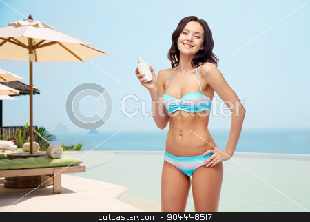 To use this stock image in your creative project, please select the size you need over to the right and click the "Add to Cart" button.
Your downloaded image will come with the Cutcaster watermark removed so don’t worry about the watermark you see on this page. happy young woman in swimsuit holding sunscreen stock photo, people, tanning, skincare, summer and beach concept - happy young woman in bikini swimsuit holding sunscreen bottle over infinity edge pool at hotel resort background by Syda Productions