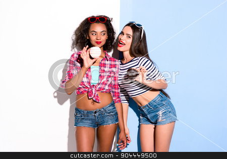 To use this stock image in your creative project, please select the size you need over to the right and click the "Add to Cart" button.
Your downloaded image will come with the Cutcaster watermark removed so don’t worry about the watermark you see on this page. Funky couple. Creative concept of beautiful sexy girls. stock photo, Colorful picture of beautiful slim young women on white and blue background. Girls holding donuts. One girl trying to bite friend's donut by Dmytro Sidelnikov