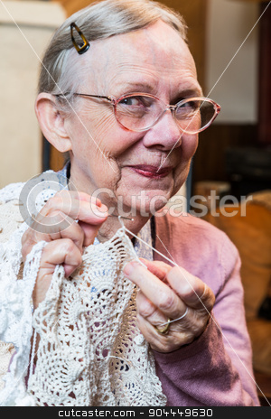To use this stock image in your creative project, please select the size you need over to the right and click the "Add to Cart" button.
Your downloaded image will come with the Cutcaster watermark removed so don’t worry about the watermark you see on this page. Smiling Elderly Woman with Crochet stock photo, Elderly woman in pink sweater crocheting with demure smile by Scott Griessel