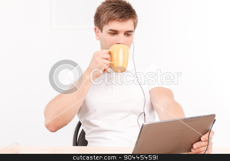To use this stock image in your creative project, please select the size you need over to the right and click the "Add to Cart" button.
Your downloaded image will come with the Cutcaster watermark removed so don’t worry about the watermark you see on this page. Man talking via skype on the tablet stock photo, Portrait of a handsome young man sitting at the table holding a tablet in his hands wearing earphones, drinking coffee from big cup while listening to his partner on skype talk by Zinkevych