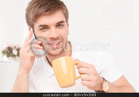 To use this stock image in your creative project, please select the size you need over to the right and click the "Add to Cart" button.
Your downloaded image will come with the Cutcaster watermark removed so don’t worry about the watermark you see on this page. Young businessman with his smartphone stock photo, Portrait of a young handsome manager sitting in the office, talking on the phone discussing some business matters smiling, holding a yellow cup of coffee by Zinkevych