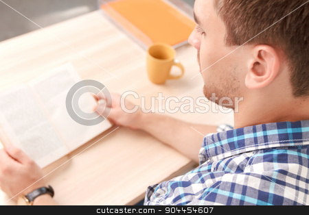 To use this stock image in your creative project, please select the size you need over to the right and click the "Add to Cart" button.
Your downloaded image will come with the Cutcaster watermark removed so don’t worry about the watermark you see on this page. Young student working on project stock photo, Top view of a young student sitting at the table holding a book and reading it preparing for exams at university, selective focus by Zinkevych