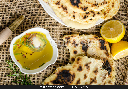 To use this stock image in your creative project, please select the size you need over to the right and click the "Add to Cart" button.
Your downloaded image will come with the Cutcaster watermark removed so don’t worry about the watermark you see on this page. Indian bread naan stock photo, Indian bread with rosemary, garlic and olive oil by Peteer