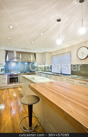 To use this stock image in your creative project, please select the size you need over to the right and click the "Add to Cart" button.
Your downloaded image will come with the Cutcaster watermark removed so don’t worry about the watermark you see on this page. Spacious contemporary kitchen stock photo, Spacious contemporary kitchen with a beuatiful clock hanging on a wall, a big kitchen island and a wooden table by JRstock