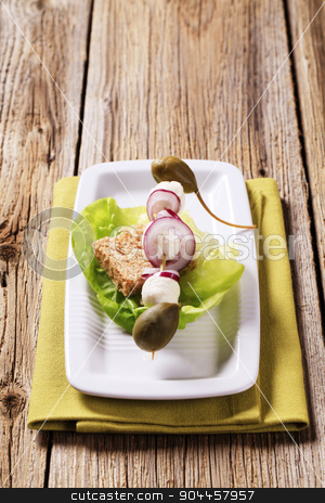 To use this stock image in your creative project, please select the size you need over to the right and click the "Add to Cart" button.
Your downloaded image will come with the Cutcaster watermark removed so don’t worry about the watermark you see on this page. Vegetarian appetizer stock photo, Mozzarella cheese, capers and onion on a wooden skewer by Digifoodstock