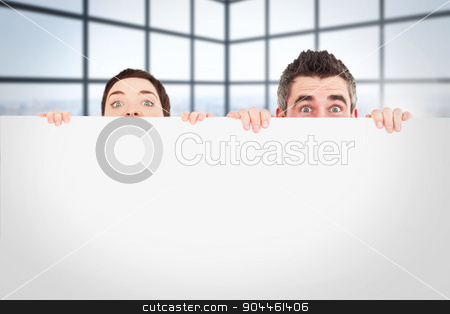 To use this stock image in your creative project, please select the size you need over to the right and click the "Add to Cart" button.
Your downloaded image will come with the Cutcaster watermark removed so don’t worry about the watermark you see on this page. Composite image of man and woman hiding behind a white board wit stock photo, Man and woman hiding behind a white board with room for copy space against room with large windows showing city by Wavebreak Media