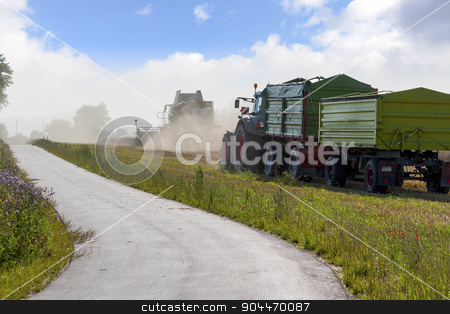 To use this stock image in your creative project, please select the size you need over to the right and click the "Add to Cart" button.
Your downloaded image will come with the Cutcaster watermark removed so don’t worry about the watermark you see on this page. tractor with two trailers and combine harvester harvesting next stock photo, tractor with two trailers and combine harvester harvesting next to a road in a wheat field by Maren Winter