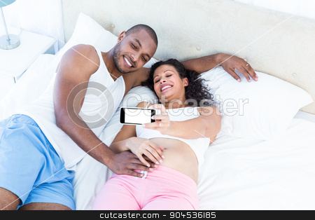 To use this stock image in your creative project, please select the size you need over to the right and click the "Add to Cart" button.
Your downloaded image will come with the Cutcaster watermark removed so don’t worry about the watermark you see on this page. Happy couple clicking selfie while lying on bed stock photo, Happy couple clicking selfie while lying on bed at home by Wavebreak Media