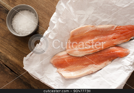 To use this stock image in your creative project, please select the size you need over to the right and click the "Add to Cart" button.
Your downloaded image will come with the Cutcaster watermark removed so don’t worry about the watermark you see on this page. Two raw rainbow trout fillets stock photo, Two gourmet raw rainbow trout fillets lying on crumpled white paper with a ramekin of rock salt alongside waiting to be cooked, overhead view by Stephen Gibson