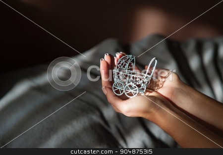 To use this stock image in your creative project, please select the size you need over to the right and click the "Add to Cart" button.
Your downloaded image will come with the Cutcaster watermark removed so don’t worry about the watermark you see on this page. Pregnancy concept: woman hand holding small toy stroller stock photo, Pregnancy concept: woman hand holding small toy stroller in front by timonko