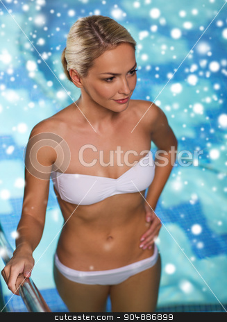 To use this stock image in your creative project, please select the size you need over to the right and click the "Add to Cart" button.
Your downloaded image will come with the Cutcaster watermark removed so don’t worry about the watermark you see on this page. happy woman raising upstairs in swimming pool stock photo, people, beauty, spa, healthy lifestyle and relaxation concept - beautiful young woman in bikini swimsuit raising upstairs in swimming pool with snow effect by Syda Productions