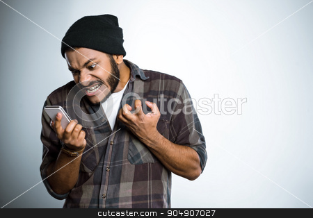 To use this stock image in your creative project, please select the size you need over to the right and click the "Add to Cart" button.
Your downloaded image will come with the Cutcaster watermark removed so don’t worry about the watermark you see on this page. Freestyle photo with young mulatto stock photo, Young mixed race man with beard standing on grey background. Angry young man screaming at mobile phone by Dmytro Sidelnikov