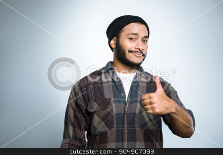 To use this stock image in your creative project, please select the size you need over to the right and click the "Add to Cart" button.
Your downloaded image will come with the Cutcaster watermark removed so don’t worry about the watermark you see on this page. Freestyle photo with young mulatto stock photo, Young mixed race man with beard standing on grey background. Young man smiling and showing thumb up by Dmytro Sidelnikov