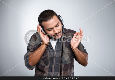 To use this stock image in your creative project, please select the size you need over to the right and click the "Add to Cart" button.
Your downloaded image will come with the Cutcaster watermark removed so don’t worry about the watermark you see on this page. Freestyle photo with young mulatto stock photo, Young mixed race man with beard standing on grey background. Young man listening to music with headphones by Dmytro Sidelnikov