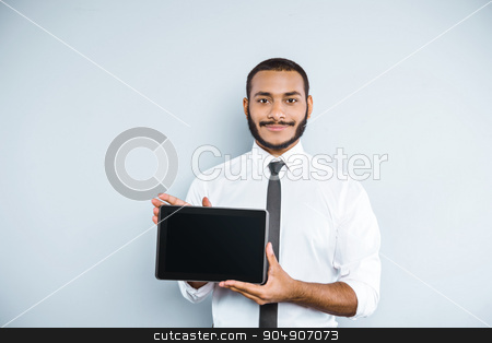 To use this stock image in your creative project, please select the size you need over to the right and click the "Add to Cart" button.
Your downloaded image will come with the Cutcaster watermark removed so don’t worry about the watermark you see on this page. Freestyle photo with young mulatto stock photo, Young mixed race businessman with beard standing on grey background. Young man smiling and showing tablet computer by Dmytro Sidelnikov