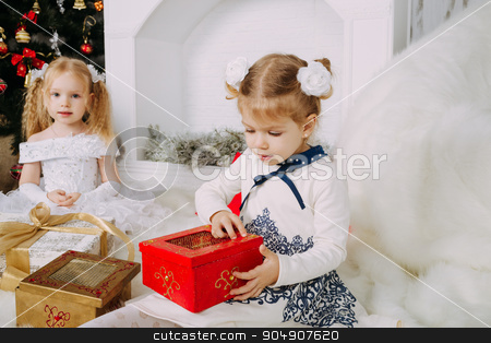 To use this stock image in your creative project, please select the size you need over to the right and click the "Add to Cart" button.
Your downloaded image will come with the Cutcaster watermark removed so don’t worry about the watermark you see on this page. Cute beautiful girl opens Christmas gift stock photo, Two blond little girls with Christmas gifts by sunapple