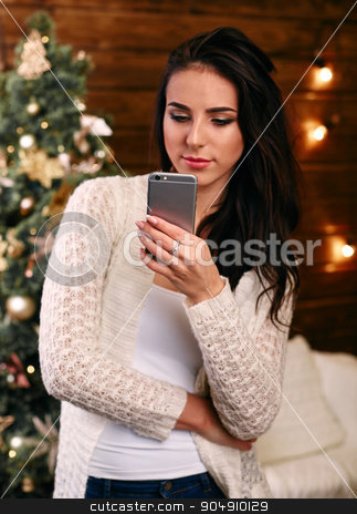 To use this stock image in your creative project, please select the size you need over to the right and click the "Add to Cart" button.
Your downloaded image will come with the Cutcaster watermark removed so don’t worry about the watermark you see on this page. Happy young woman writing sms near christmas tree stock photo, Happy young woman writing sms near christmas tree by mykhalets