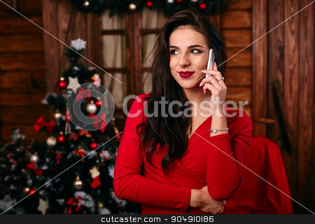 To use this stock image in your creative project, please select the size you need over to the right and click the "Add to Cart" button.
Your downloaded image will come with the Cutcaster watermark removed so don’t worry about the watermark you see on this page. Young woman in red dress talking on mobile phone at Christmas decorated home stock photo, Young woman in red dress talking on mobile phone at Christmas decorated home by mykhalets