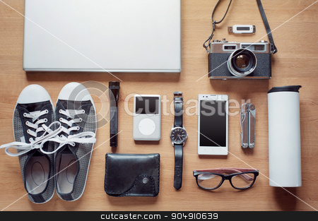 To use this stock image in your creative project, please select the size you need over to the right and click the "Add to Cart" button.
Your downloaded image will come with the Cutcaster watermark removed so don’t worry about the watermark you see on this page. Overhead of essentials for modern young person stock photo, Outfit of modern traveler, student, woman or guy. Overhead of essentials on wooden background: camera, smart phone, glasses, flashlight, laptop, wallet, watch, gumshoes, thermos, multitool, mp3 player by Oleksii